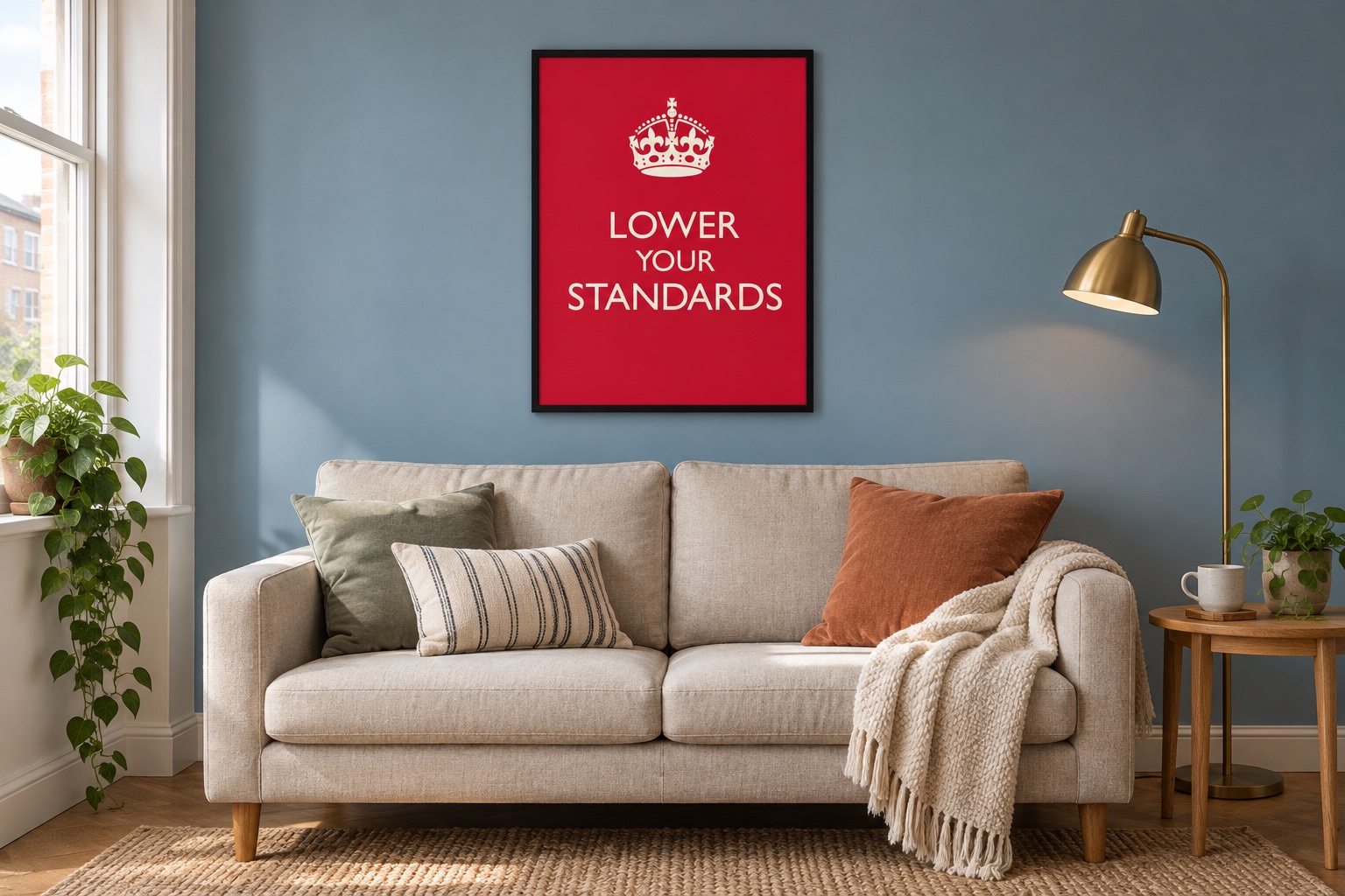 compact living room with a red Lower Your Standards print above a linen sofa